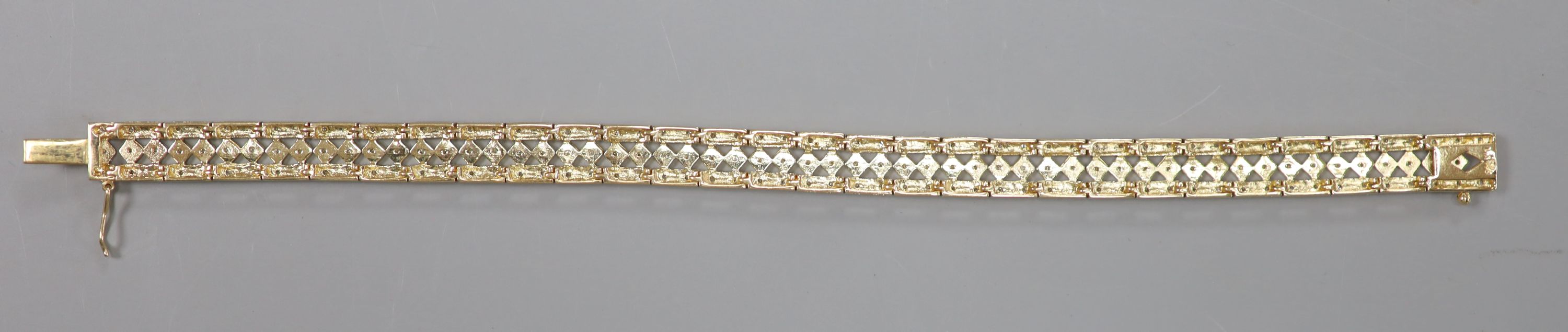 A modern pierced 9ct gold and diamond chip set line bracelet, length 18.5cm, gross 16.4 grams.